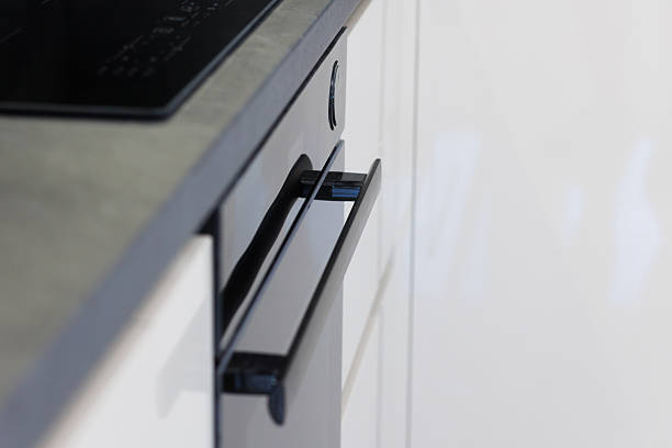 istock Modern black kitchen drawer handle pulls in open position against sleek white cabinetry 2217111892
