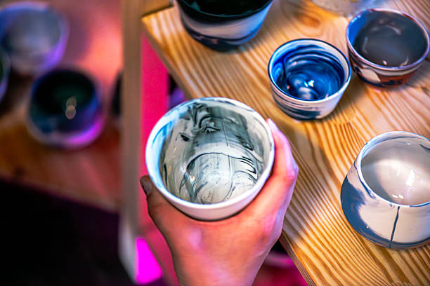 A vibrant close-up of uniquely crafted ceramic coffee cups from a creative workshop. Emphasizing cultural expression, lifelong learning, and modern educational environments.