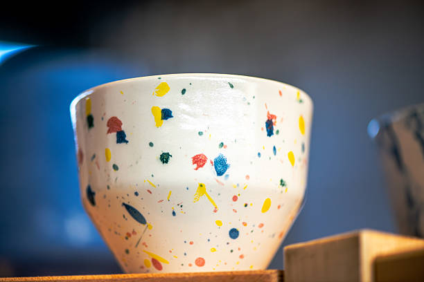 A vibrant close-up of uniquely crafted ceramic coffee cups from a creative workshop. Emphasizing cultural expression, lifelong learning, and modern educational environments.