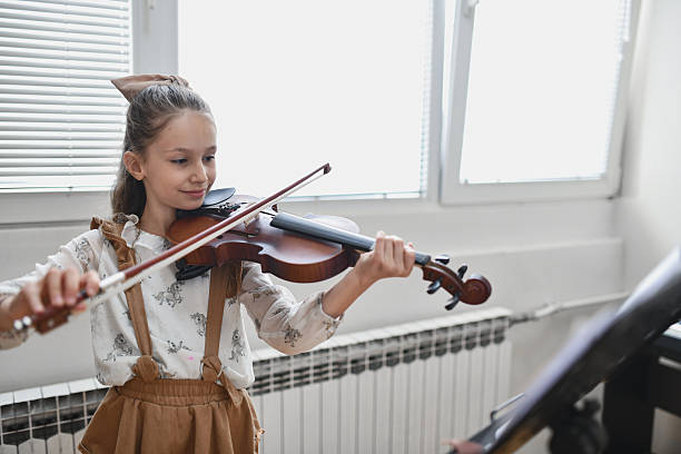 istock Happy Girl Appearing Fulfilled While Performing On Violin With Strong Concentration 2217113400