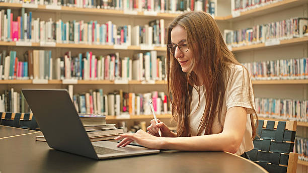istock Happy and focused female student studying in a modern library. 2217113404