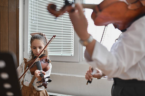 istock Young Student Violinist and Teacher Playing Together in Sync 2217113472