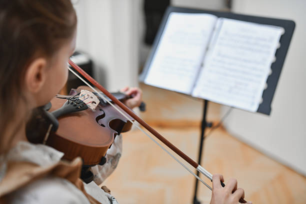 istock Student Violinist Concentrating On Notes While Playing And Reading From Music Stand 2217114375
