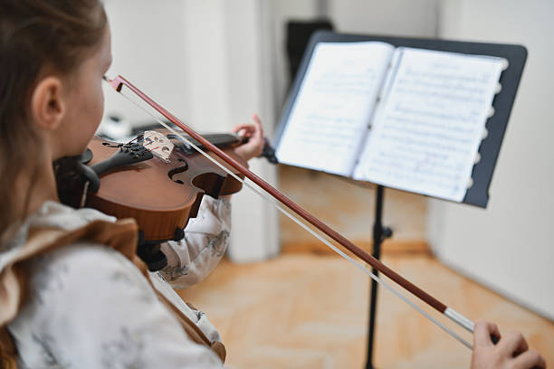 istock Focused Violin Student Reading Sheet Music Carefully While Playing With Steady Hands 2217114467