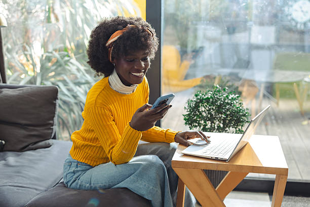 istock Woman enjoying productive work from home while using phone and laptop 2217114671