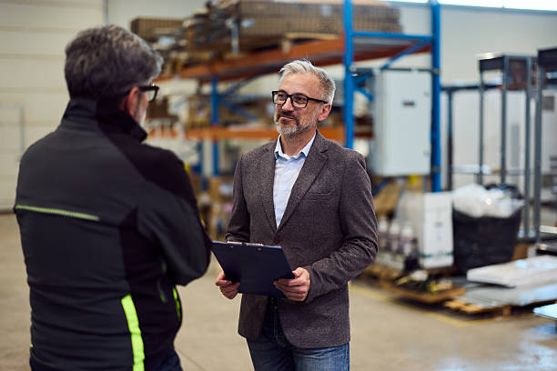 istock Businessman Discussing Work Inside Industrial Warehouse Environment with Colleague 2217115044