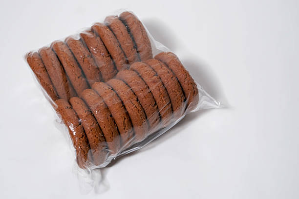 istock Stack of chocolate chip cookies sealed in plastic film on white background. 2217115492