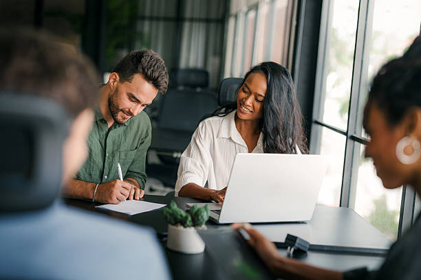 istock Busy smiling executive business team using digital devices in office. Diverse professional people 2217115579