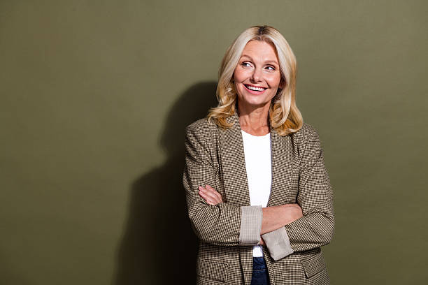 istock Portrait of beautiful mature confident lady folded arms looking empty space planning professional career isolated on khaki color background 2217117046