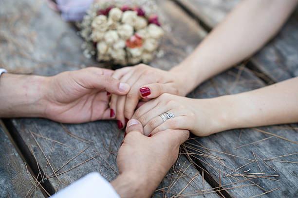 bride and groom hands on wooden table