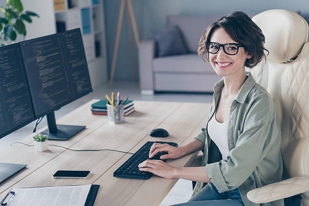 istock Photo of pretty smiling student girl practicing developing website young system administrator working in office 2217117403