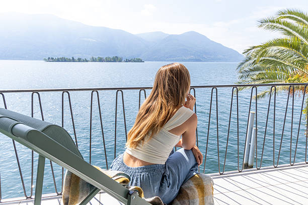 istock Woman Relaxing on Balcony Overlooking Scenic Lake 2217117939