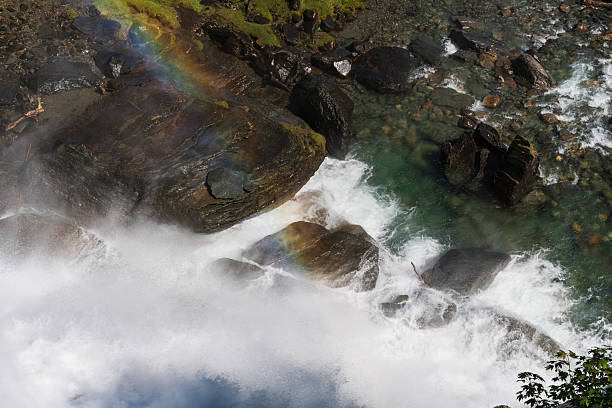 Powerful Norwegian waterfall, top view: turbulent water, ancient rocks, and a bright rainbow in refreshing natural spray.High quality photo