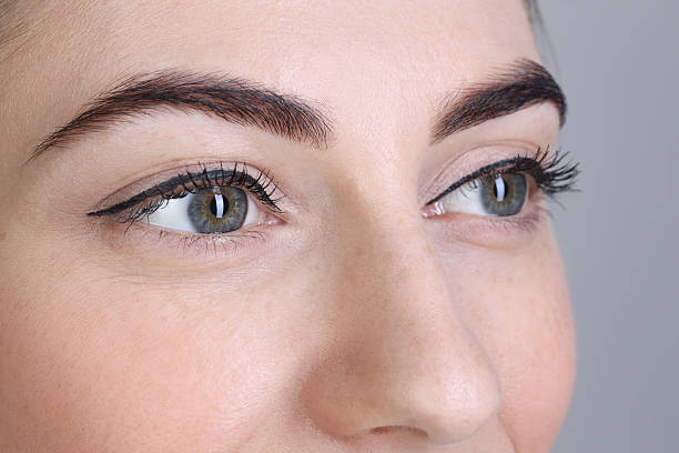 istock Woman after brow lamination procedure on grey background, closeup 2217118232
