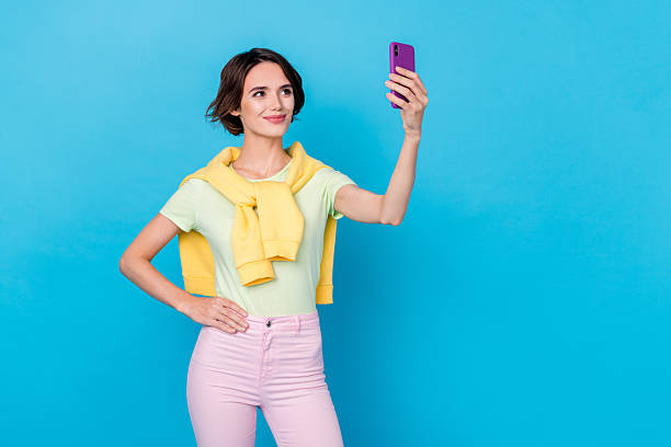 istock Photo of adorable cute lady dressed yellow pullover tacking selfie modern gadget isolated blue color background 2217118714