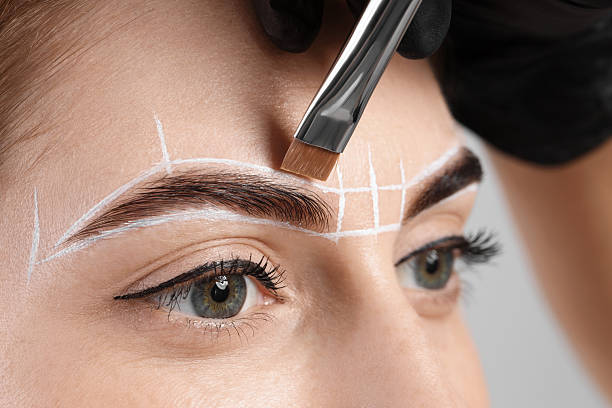 istock Young woman undergoing henna eyebrows dyeing procedure, closeup 2217119381