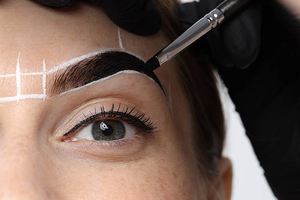istock Young woman undergoing henna eyebrows dyeing procedure, closeup 2217119511