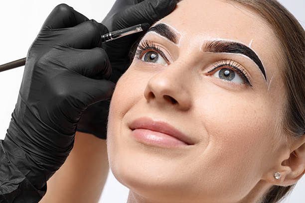 istock Young woman undergoing henna eyebrows dyeing procedure on light background, closeup 2217119524