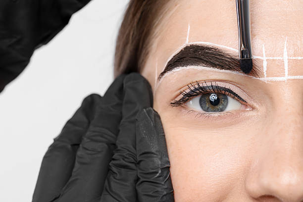 istock Young woman undergoing henna eyebrows dyeing procedure on light background, closeup 2217119650