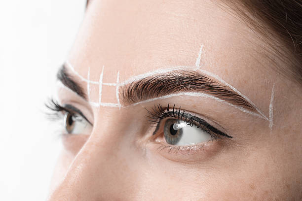 istock Young woman during henna eyebrows dyeing procedure on white background, closeup 2217119716