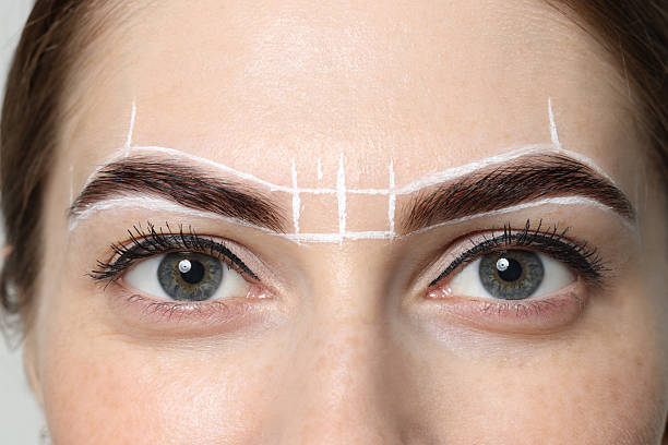 istock Young woman during henna eyebrows dyeing procedure, closeup 2217119718