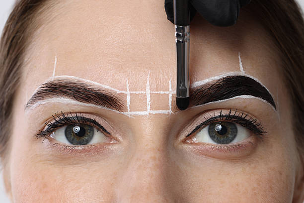 istock Young woman undergoing henna eyebrows dyeing procedure, closeup 2217119812