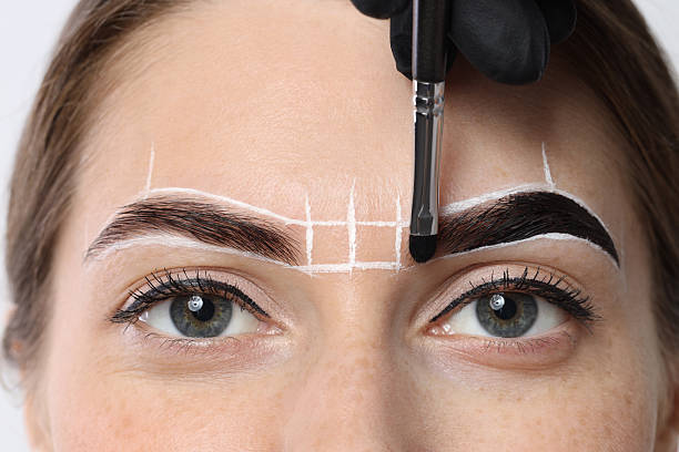 istock Young woman undergoing henna eyebrows dyeing procedure, closeup 2217119852