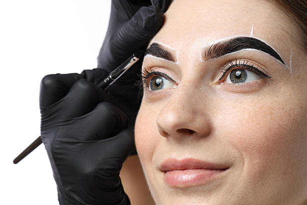 istock Young woman undergoing henna eyebrows dyeing procedure on light background, closeup 2217119909