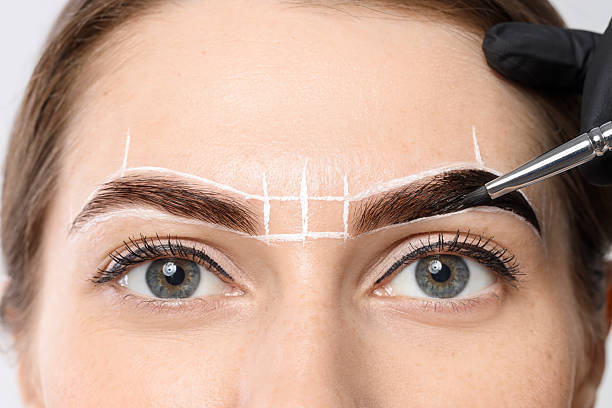 istock Young woman undergoing henna eyebrows dyeing procedure, closeup 2217119940