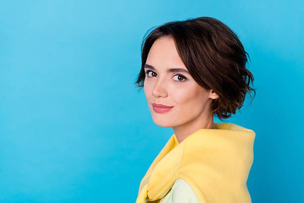 istock Photo of shiny adorable lady dressed yellow pullover smiling empty space isolated blue color background 2217121038