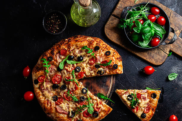 istock Appetizing pizza with ham, tomatoes and cheese close-up. Thin pizza 2217121306