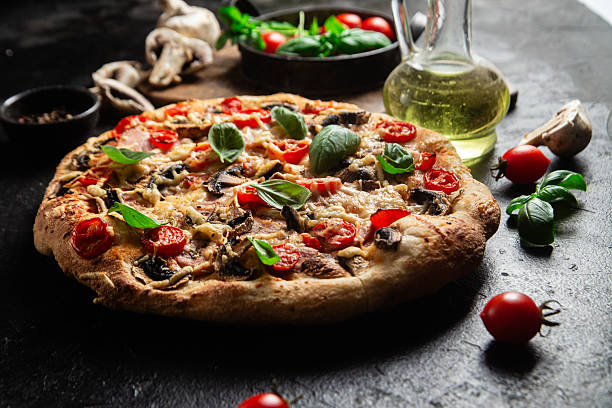 istock Appetizing pizza with ham, tomatoes and cheese close-up. Thin pizza 2217121356