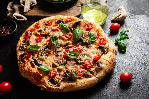 istock Appetizing pizza with ham, tomatoes and cheese close-up. Thin pizza 2217121357