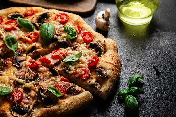 istock Appetizing pizza with ham, tomatoes and cheese close-up. Thin pizza 2217121370
