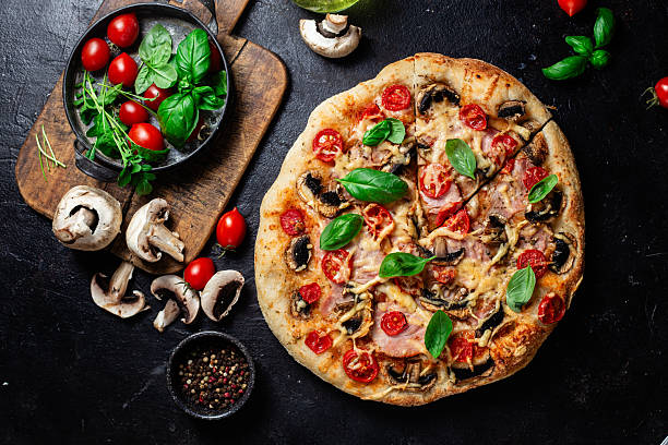 istock Appetizing pizza with ham, tomatoes and cheese close-up. Thin pizza 2217121377