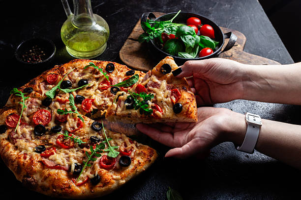 istock Appetizing pizza with ham, tomatoes and cheese close-up. Thin pizza 2217121383