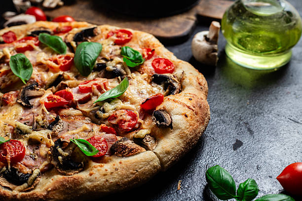 istock Appetizing pizza with ham, tomatoes and cheese close-up. Thin pizza 2217121396