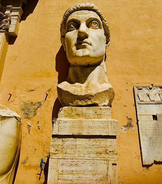 Rome, Italy: 05/26/2025 - In the courtyard of Palazzo dei Conservatori, is an array of monumental body parts for one of the important sculptures of the ancient Roman world, the Colossus of Constantine. in its original form, the statue would have been over 40 feet tall.The remains are white marble fragments of the limbs and head of emperor Constantine the great.Two feet, a kneecap, a bicep, and chest fragment make up the rest of the remaining sculpture.