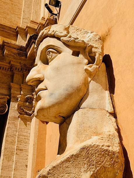 Rome, Italy: 05/26/2025 - In the courtyard of Palazzo dei Conservatori, is an array of monumental body parts for one of the important sculptures of the ancient Roman world, the Colossus of Constantine. in its original form, the statue would have been over 40 feet tall.The remains are white marble fragments of the limbs and head of emperor Constantine the great.Two feet, a kneecap, a bicep, and chest fragment make up the rest of the remaining sculpture.