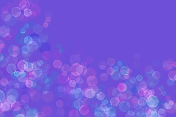 A captivating purple bokeh background featuring an array of colorful light circles in shades of pink, blue, and purple.