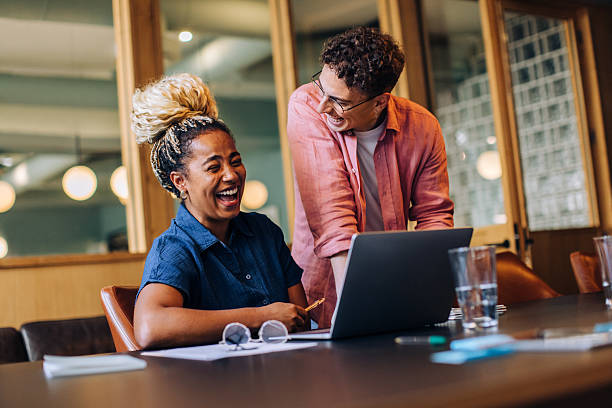 istock Two colleagues laughing together while working on a project at the office 2217125779
