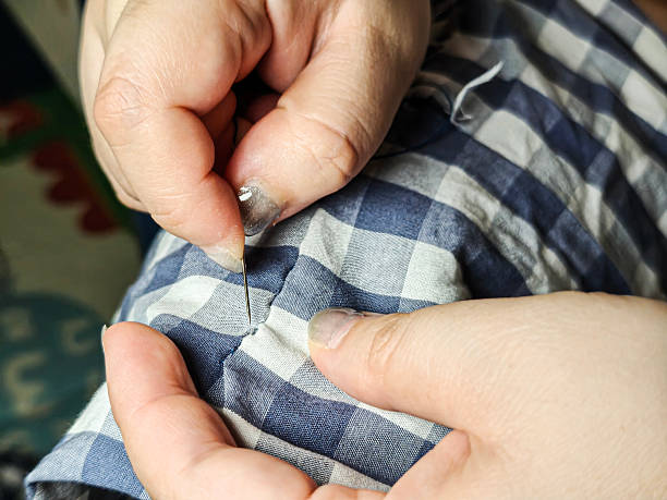 istock Mend old clothes with needles and threads 2217126634