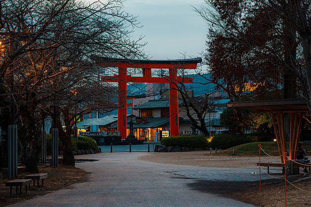 Fujinomiya, Japan - Dec 11, 2023: A large red torii gate stands prominently in Fujinomiya, Japan, amidst modern urban surroundings and evening light.