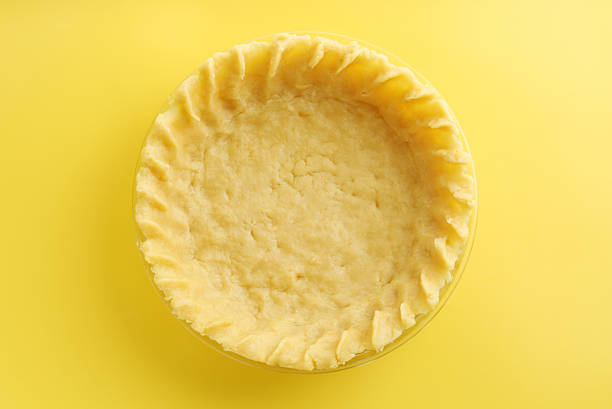 Cooking homemade pie. Raw dough on yellow background, top view