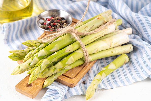 istock Raw fresh organic asparagus stems on kitchen table background 2217137065