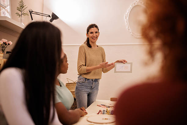 istock Embroidery Teacher Showing Craft Techniques to Students 2217137159