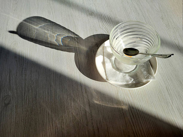 istock An empty ice cream bowl on the table with a spoon and shadows. View from above. 2217137421