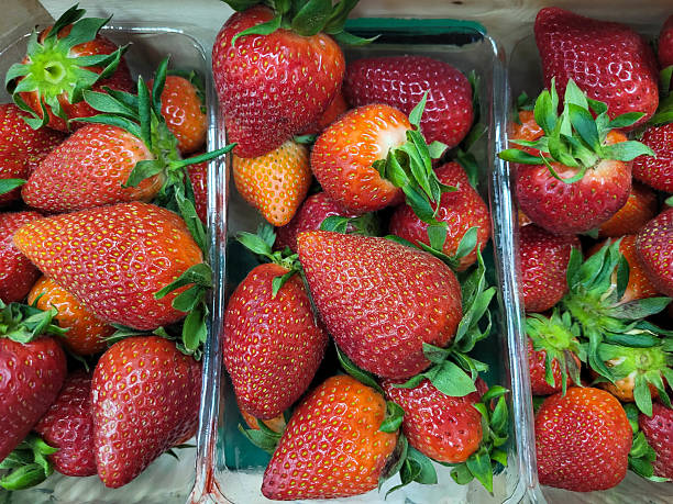 istock Fresh early strawberries in open plastic containers in the shop window. 2217137585