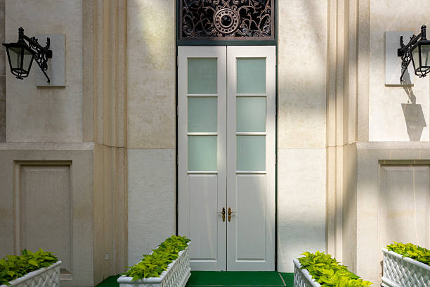 A small path covered in green carpet, with flower pots planted on both sides, leads to a white door. The scene is meticulously crafted, evoking a sense of tranquility and precision. Ideal for showcasing architectural or landscaping concepts.