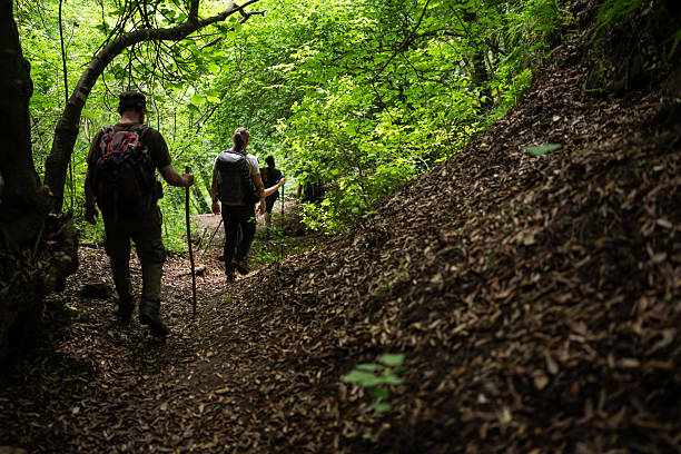 A group of pilgrims walks through a deep, moss-covered ravine—locally known as a \